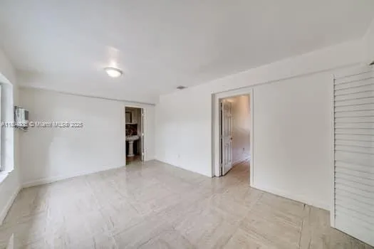 an empty room with closet and windows