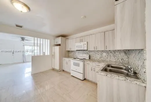 a kitchen with granite countertop a sink stove and cabinets