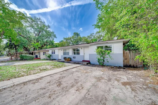 a view of a house with backyard and a tree