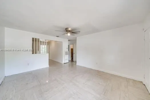 a view of a big room with windows and chandelier fan