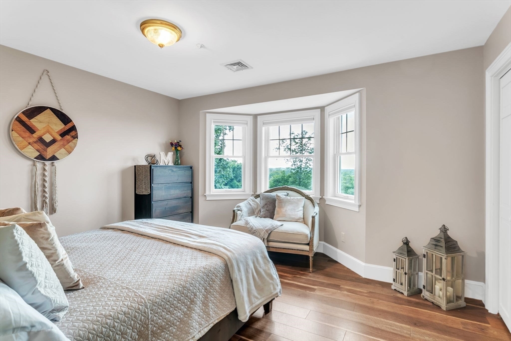 11 Echo Hill Road Wilbraham, MA 01095 - Photo 22 of 42 a bedroom with a bed and a chandelier