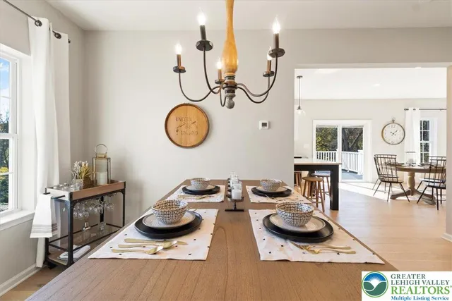 a kitchen with stainless steel appliances kitchen island granite countertop a table chairs in it and wooden floors