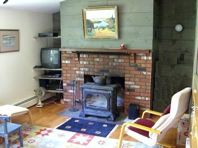 809 Leonhardt Road Becket, MA 01223 - Photo 2 of 8 a living room with furniture a flat screen tv and a fireplace