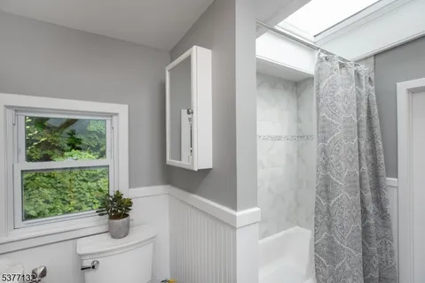 a bathroom with a shower curtain and a window