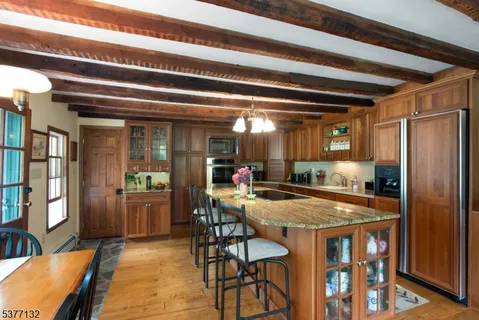 a kitchen with stainless steel appliances granite countertop a kitchen island a stove a table and chairs