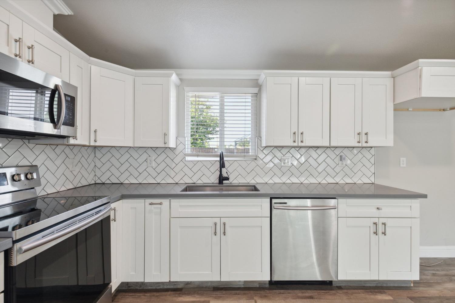345 Gettysburg Clovis, CA 93612 - Photo 11 of 25 a kitchen with white cabinets appliances and a sink