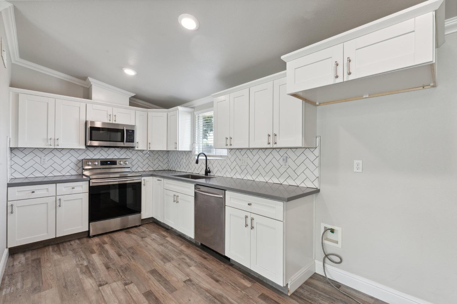 345 Gettysburg Clovis, CA 93612 - Photo 9 of 25 a kitchen with granite countertop stainless steel appliances and white cabinets