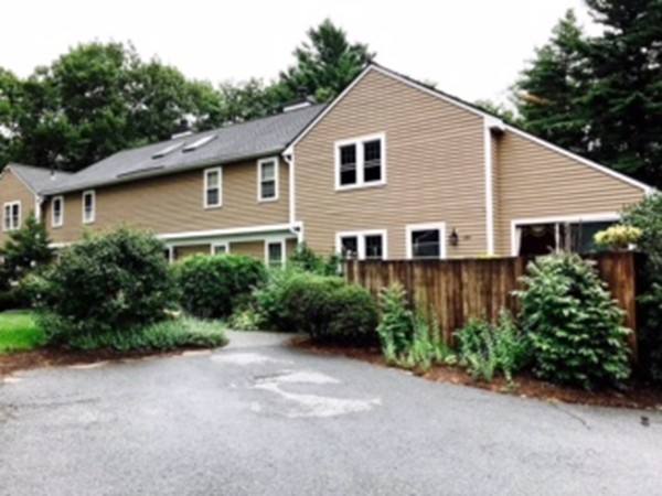 134 Russet Lane, Unit 134 Boxborough, MA 01719 - Photo 2 of 16 a view of a house with lots of plants and trees