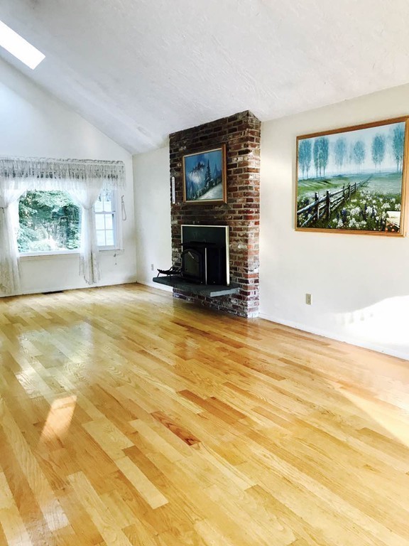 134 Russet Lane, Unit 134 Boxborough, MA 01719 - Photo 4 of 16 a view of an empty room with a fireplace and large windows