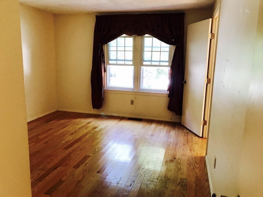 134 Russet Lane, Unit 134 Boxborough, MA 01719 - Photo 8 of 16 an empty room with wooden floor and windows