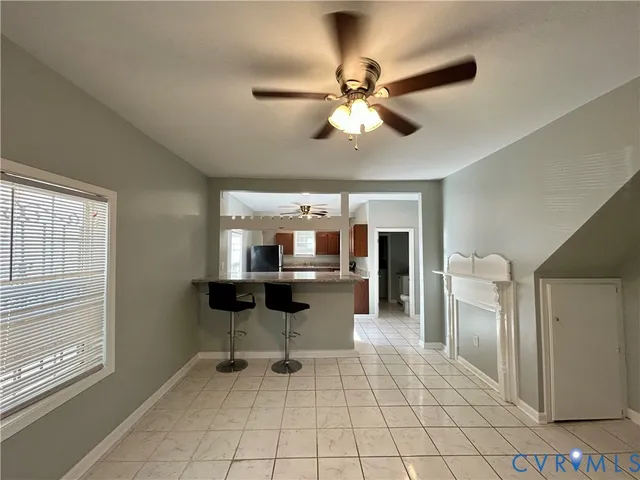 a view of a livingroom with a chair and a ceiling fan