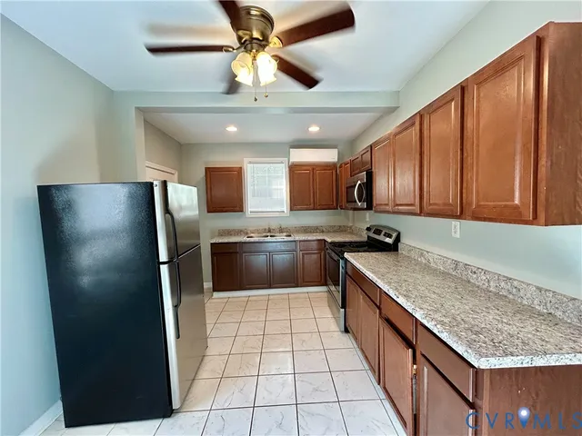 a kitchen with stainless steel appliances granite countertop a refrigerator a sink dishwasher a stove with wooden cabinets and floor