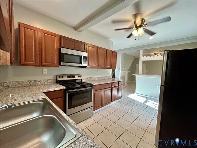 a kitchen with granite countertop a sink stainless steel appliances and a counter top space