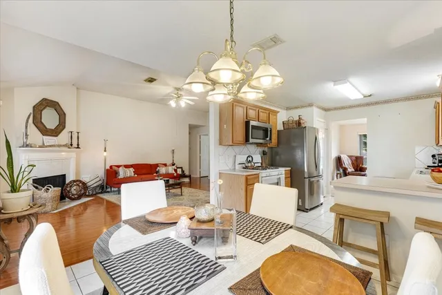 a living room with furniture a dining table and a fireplace