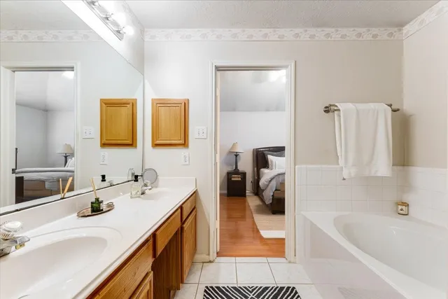 a en suite bathroom with a tub sink and mirror