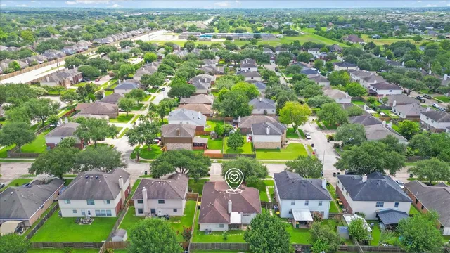 an aerial view of residential houses with outdoor space and trees