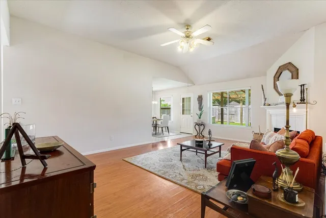 a room with chandelier fan and wooden floor