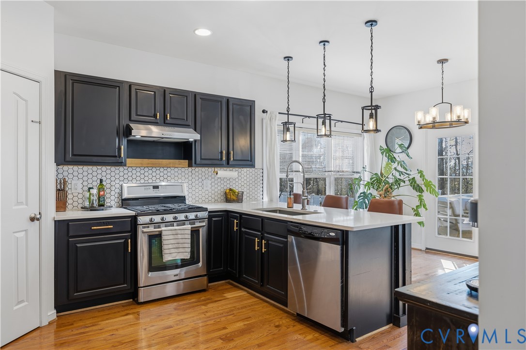 940 Gorham Court Midlothian, VA 23114 - Photo 21 of 45 a kitchen with stainless steel appliances granite countertop a sink a stove and a wooden floors