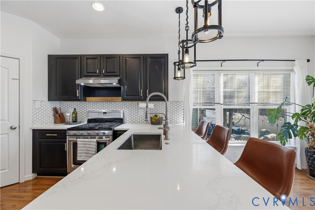 940 Gorham Court Midlothian, VA 23114 - Photo 9 of 45 a kitchen with stainless steel appliances a sink a stove a refrigerator cabinets and a dining table