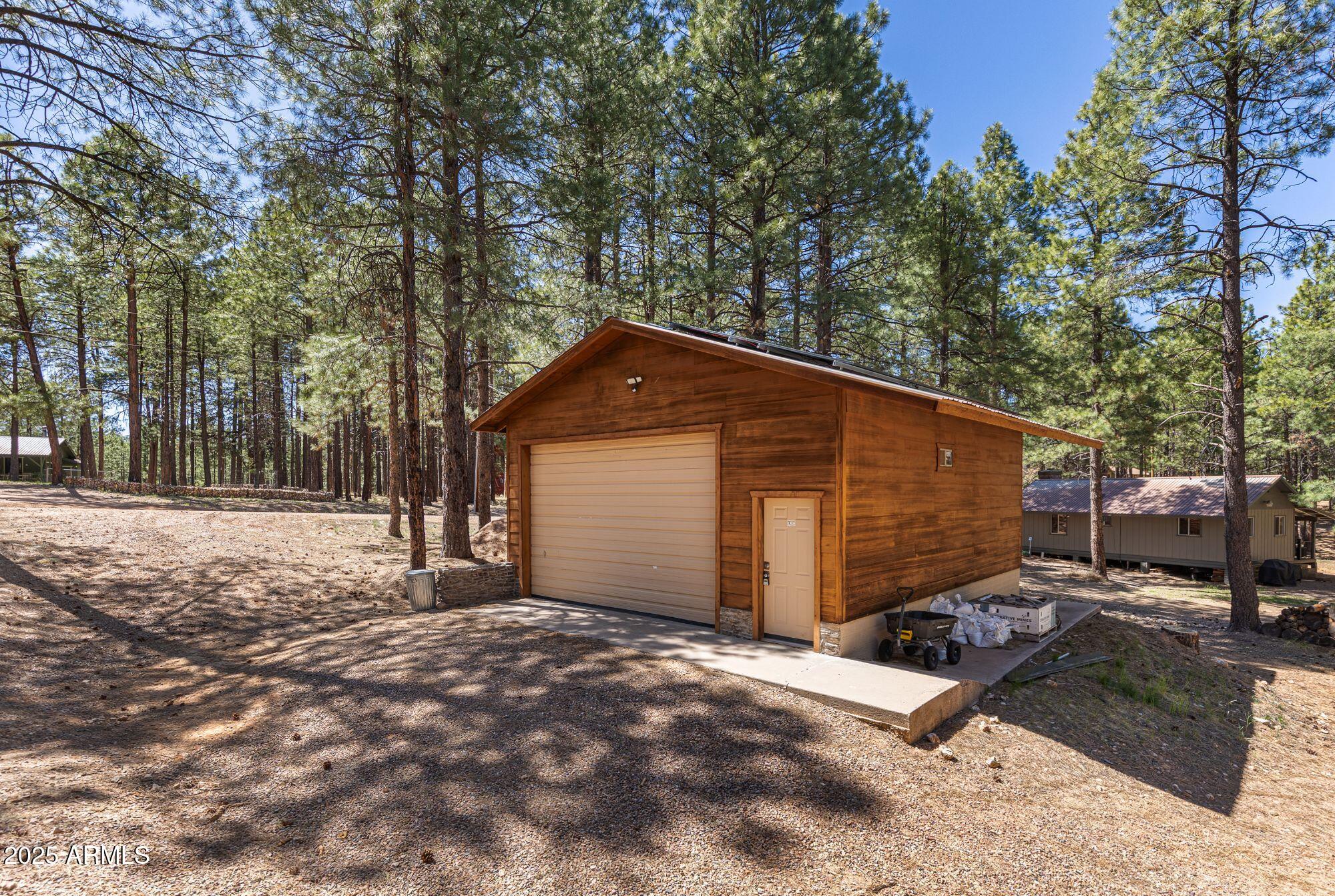 341 Pinto Road Forest Lakes, AZ 85931 - Photo 4 of 30 a backyard of a house with large trees and outdoor seating