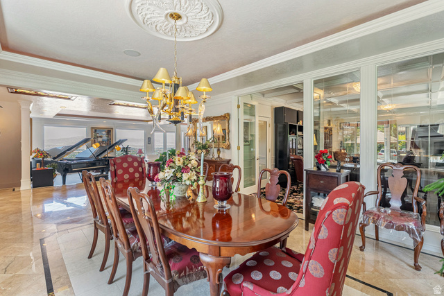 4093 North Imperial Way Provo, UT 84604 - Photo 20 of 96 Formal dining area featuring a prominent chandelier with a decorative ceiling medallion, extensive crown molding, and large format polished tile flooring