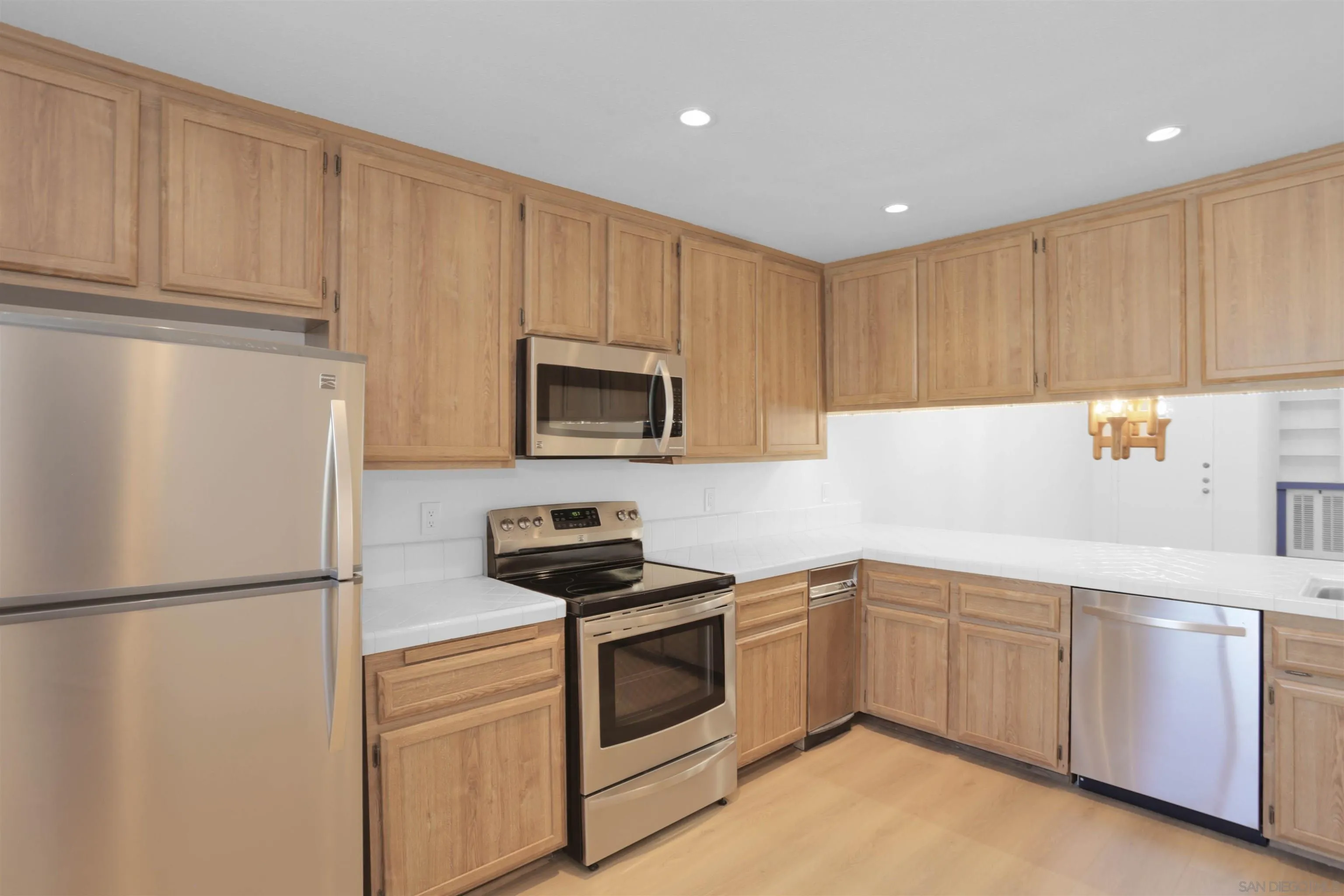 6359 Rancho Mission Road, Unit 4 San Diego, CA 92108 - Photo 10 of 48 a kitchen with white cabinets and white appliances