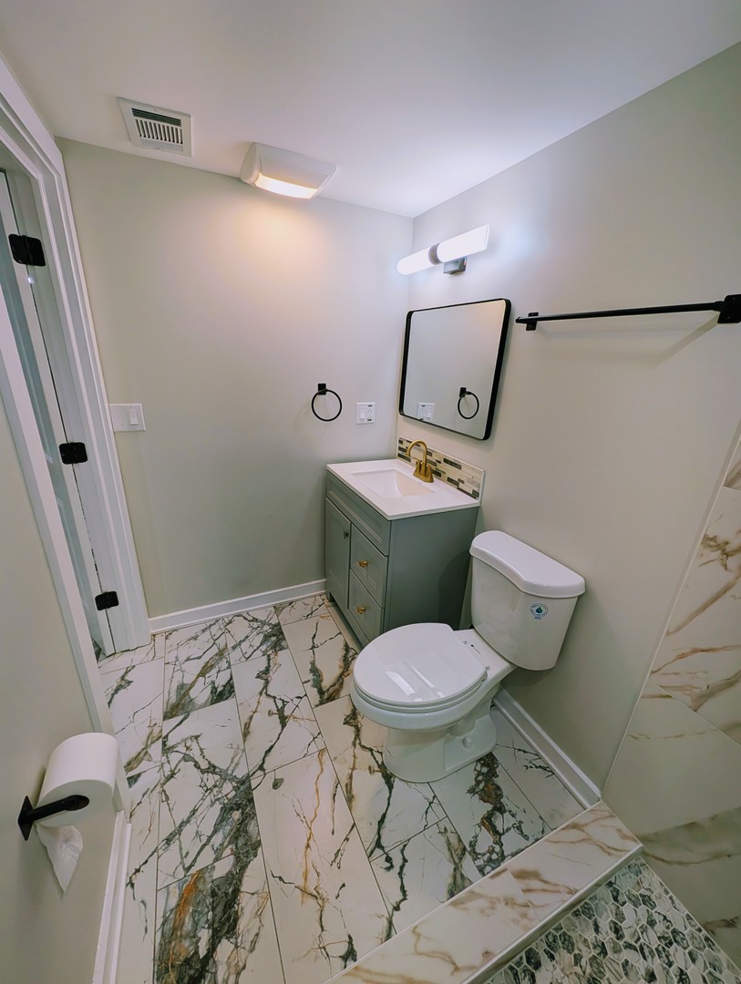 41 West 14th Place, Unit B Chicago Heights, IL 60411 - Photo 11 of 16 a bathroom with a toilet sink and mirror
