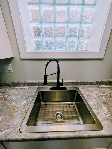 a view of kitchen island with a sink granite counter tops and a wooden floor