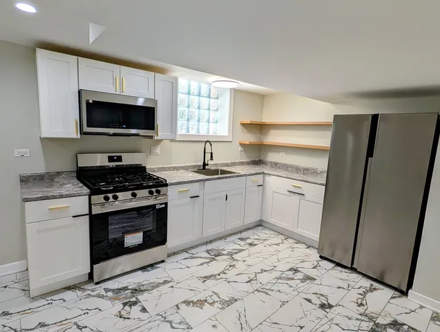 a kitchen with a sink stove and white wooden cabinets