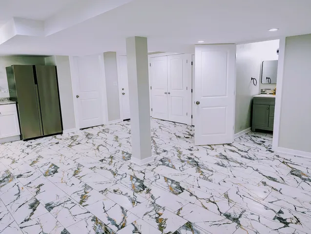 a view of a hallway with cabinet and a refrigerator