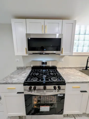 a white stove top oven sitting inside of a kitchen