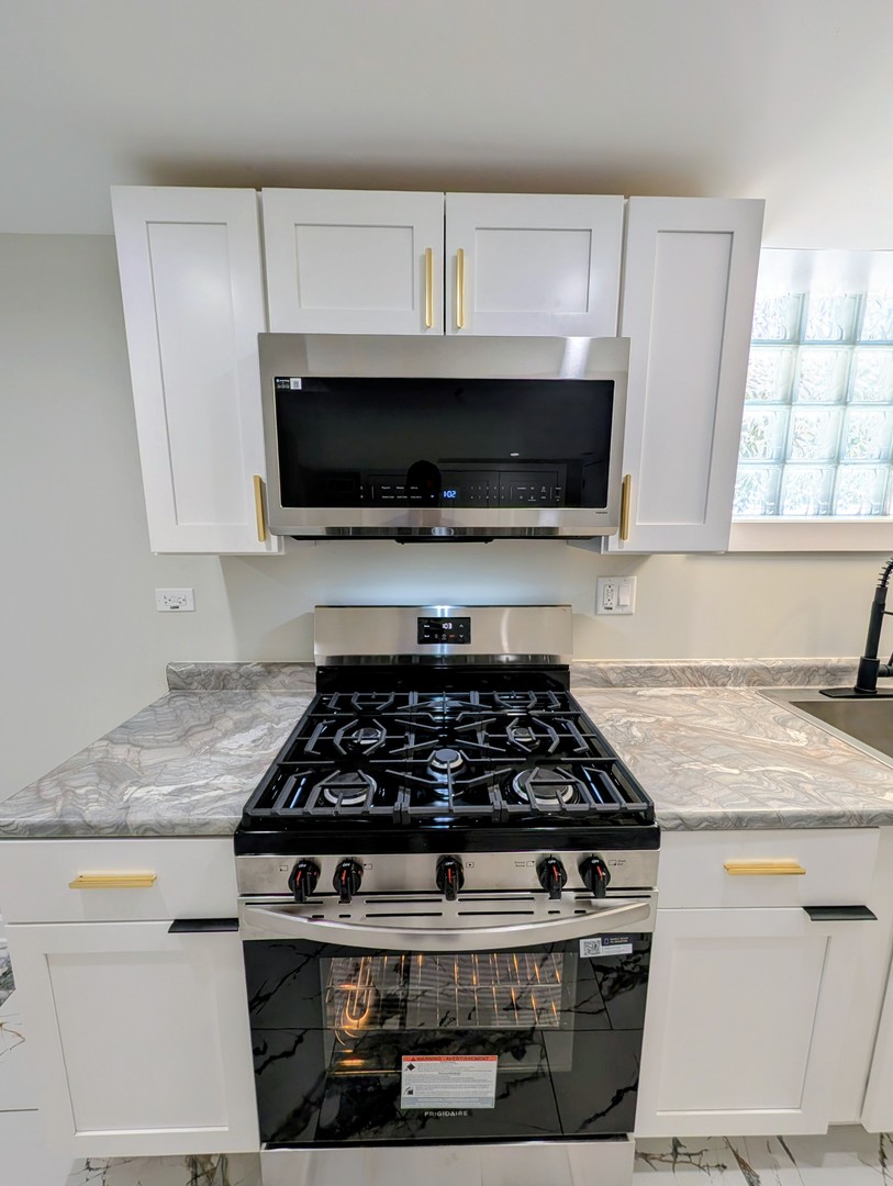 41 West 14th Place, Unit B Chicago Heights, IL 60411 - Photo 9 of 16 a white stove top oven sitting inside of a kitchen