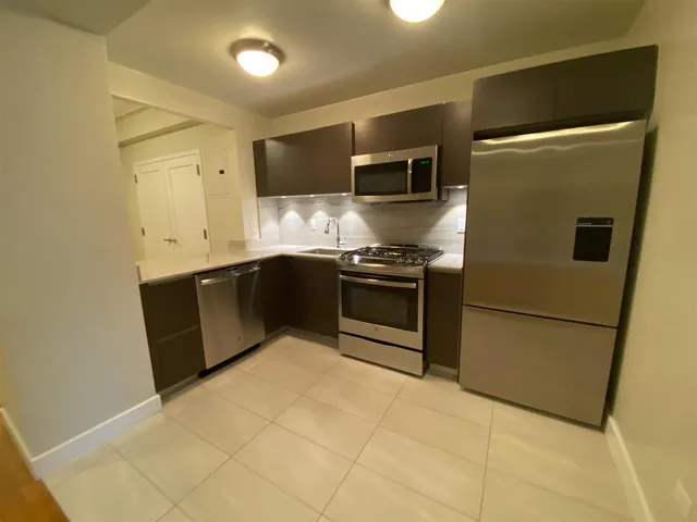 a kitchen with stainless steel appliances granite countertop a stove a sink and a refrigerator