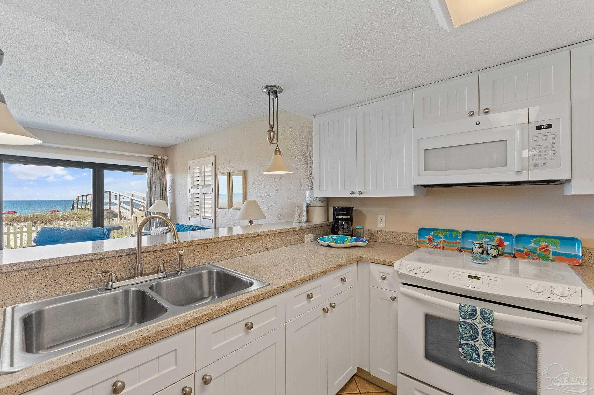 14623 Perdido Key Drive, Unit W106 Perdido Key, FL 32507 - Photo 27 of 50 a kitchen with stainless steel appliances granite countertop a sink a stove and a granite counter tops with white cabinets