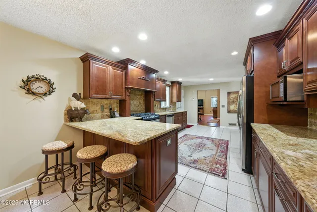 a kitchen with stainless steel appliances granite countertop table chairs sink and cabinets