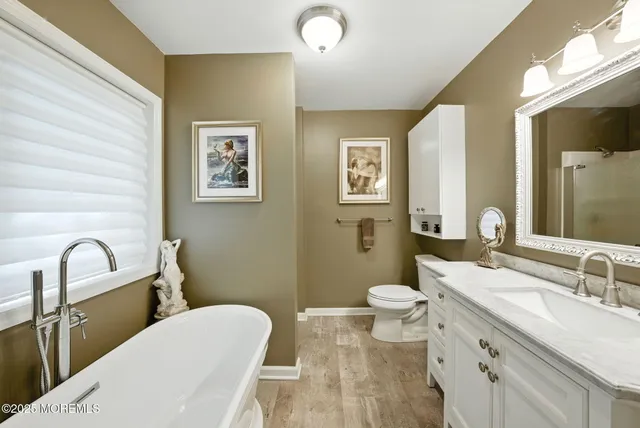 a bathroom with a granite countertop sink a toilet and shower