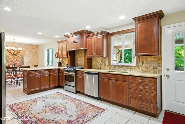 a large kitchen with kitchen island granite countertop a large window and stainless steel appliances