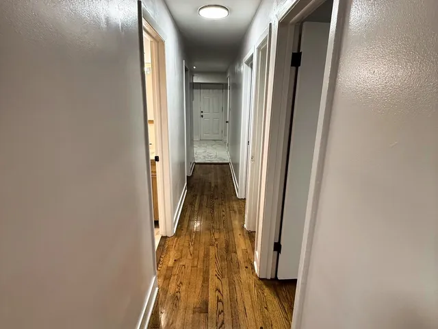 a view of a hallway with wooden floor and staircase