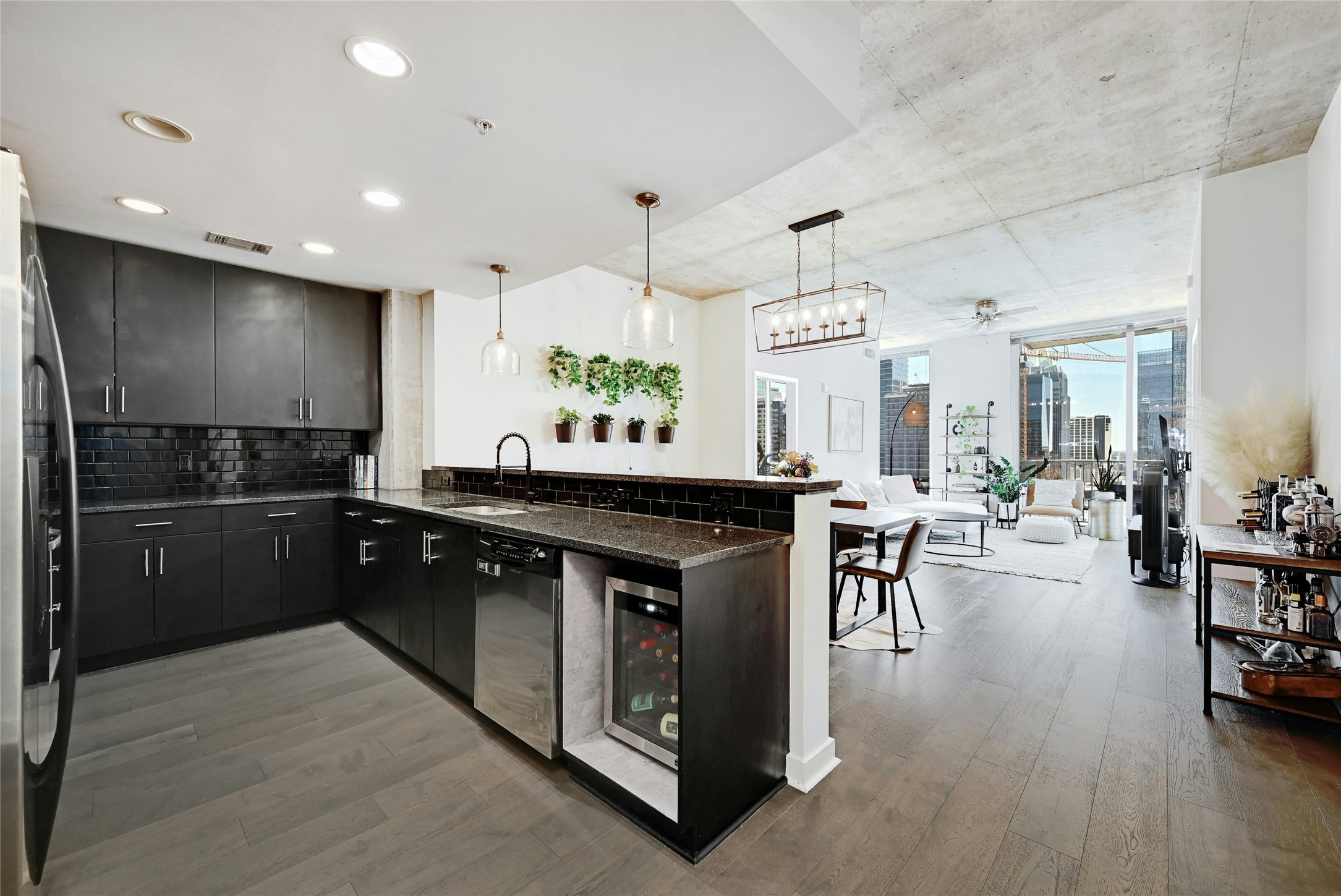 360 Nueces Street, Unit 1809 Austin, TX 78701 - Photo 8 of 25 Modern kitchen featuring dark cabinetry, dark subway tile backsplash, and a built-in wine refrigerator