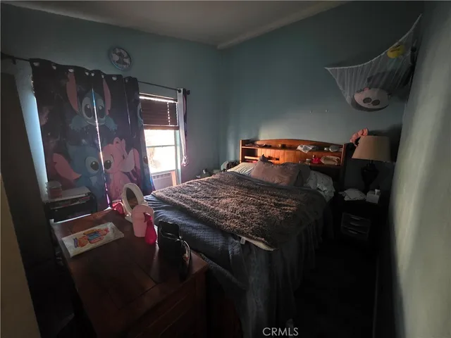 a bed sitting in a bedroom next to a window