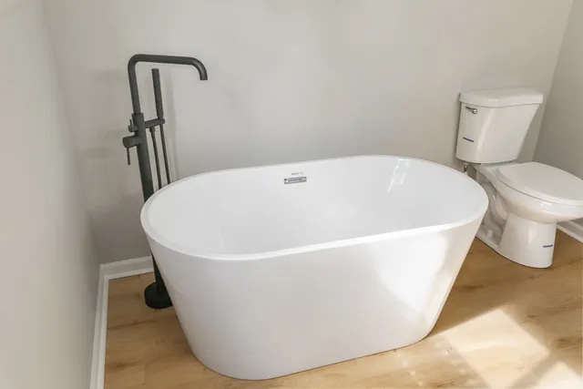 a white tub sitting next to a toilet