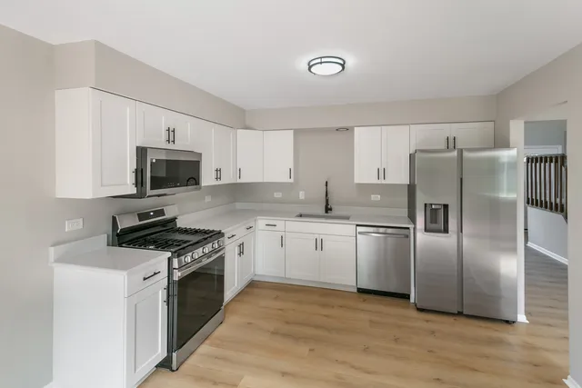 a kitchen with granite countertop a refrigerator stove and microwave
