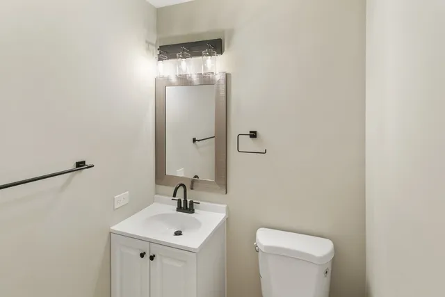 a bathroom with a toilet a sink and mirror