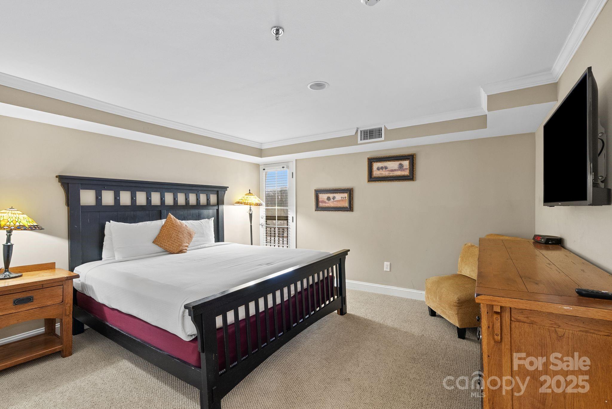 430 Bowling Park Road Asheville, NC 28803 - Photo 11 of 22 a bedroom with a bed and a flat tv screen on dresser