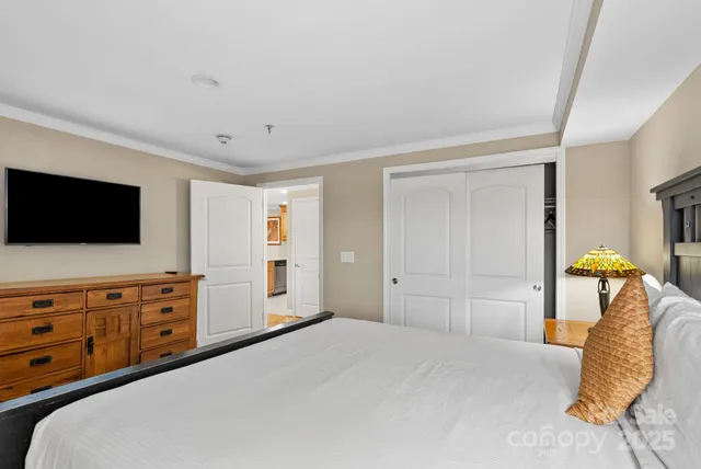 a bedroom with a bed and flat screen tv