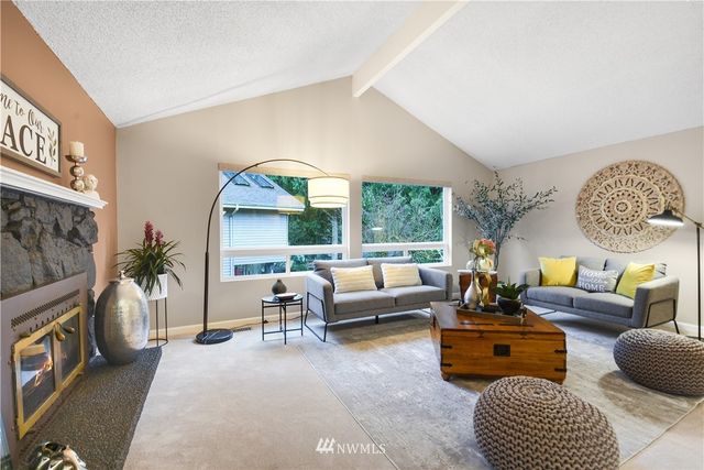 a living room with furniture a fireplace and a large window