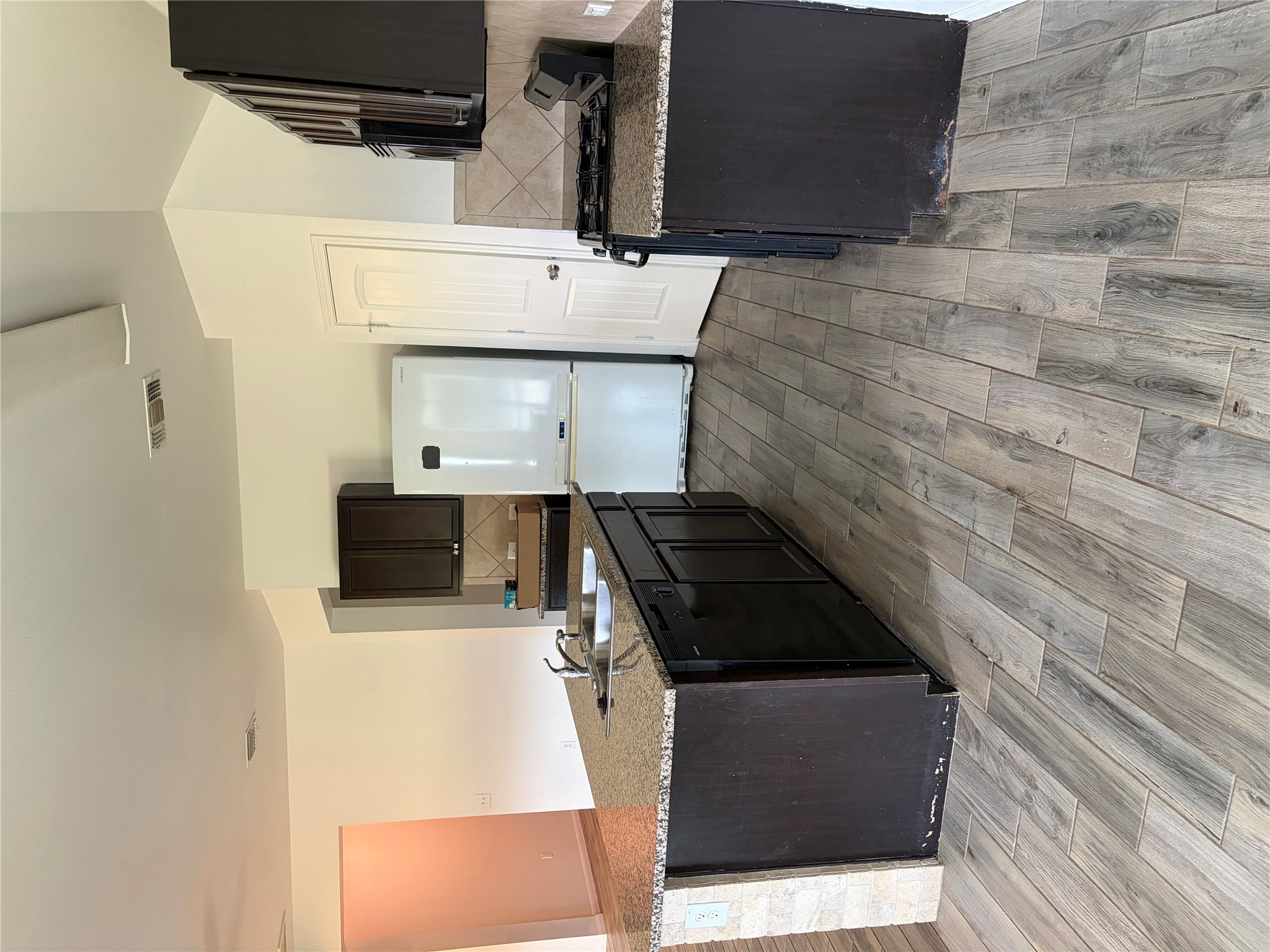 137 Rafe Court Kyle, TX 78640 - Photo 29 of 36 A well-appointed kitchen features a practical island with a double sink and durable tile flooring.