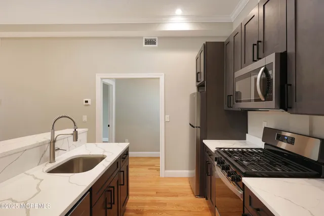 a kitchen with stainless steel appliances granite countertop a sink stove and refrigerator