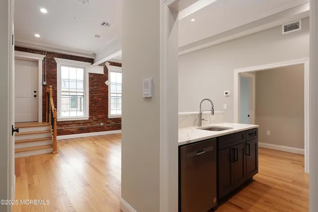 a view of a sink and cabinets with wooden floor
