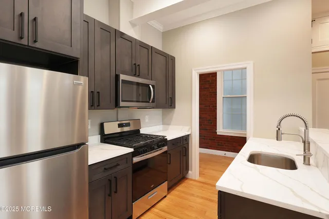 a kitchen with a refrigerator a stove a sink and a microwave